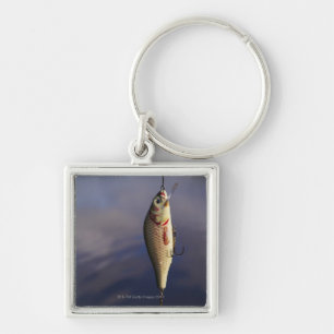 fishing lure in front of water key ring
