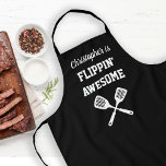 Flippin Awesome Personalised Black Grilling Apron<br><div class="desc">The perfect apron for the chef whose spatula skills are beyond compare, whether flipping burgers on the grill or pancakes on the griddle. Two crossed spatulas appear silhouetted in white under the words "Flippin' Awesome" in white capital letters on a black background. Add his name in retro script. The perfect...</div>