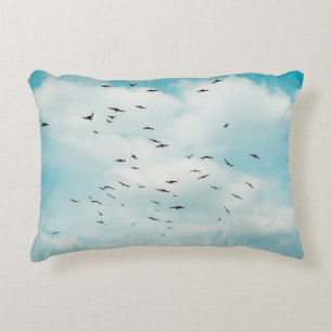 Flock of grey dove fly on vintage blue sky. above, decorative cushion