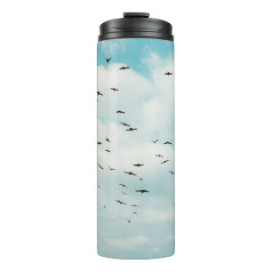 Flock of grey dove fly on vintage blue sky. above, thermal tumbler