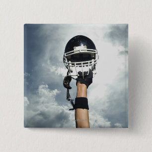 Football player holding helmet in air 15 cm square badge