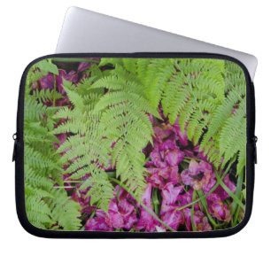 Forest ferns with pink flower petals on ground laptop sleeve