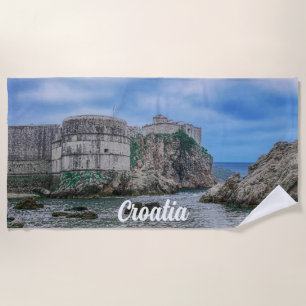 Fortress walls, rocky coast and sea in Croatia Beach Towel