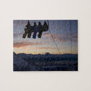 Four snowboarders are silhouetted on a ski lift jigsaw puzzle