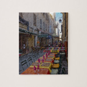 France, Corsica. Tables of cafe set up in narrow Jigsaw Puzzle