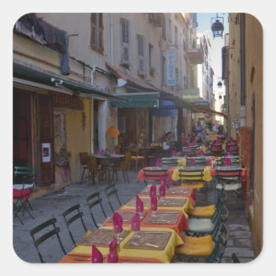 France, Corsica. Tables of cafe set up in narrow Square Sticker