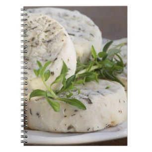 French goat cheese - chevre - with herbs on a notebook