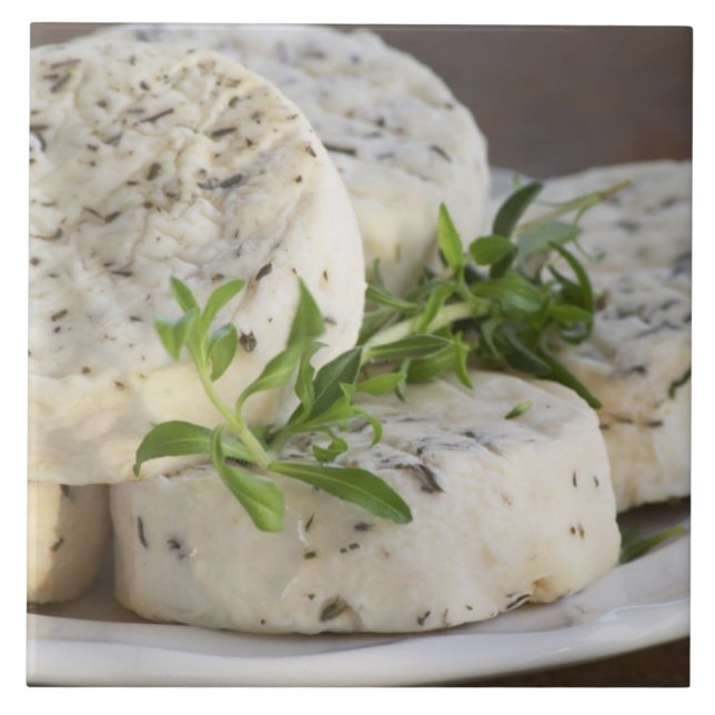 French goat cheese - chevre - with herbs on a tile (Front)