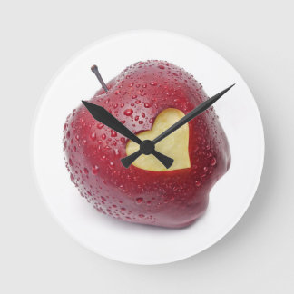Fresh red apple with a heart shaped symbol round clock
