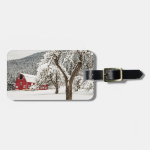 Fresh snow on red barn luggage tag