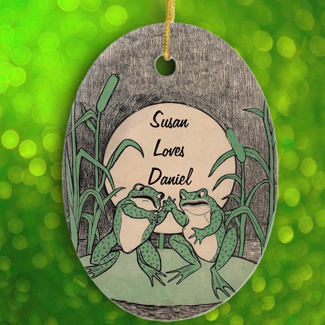 Fun Arguing Green Frog Couple on Lily Pad moon Ceramic Tree Decoration (Cute green fighting frogs on lily pad full moon reed plants on black white oval hanging ornament.)