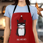 Funny Grouchy Cat Catmas Humour Apron<br><div class="desc">Get ready to cook up some holiday cheer with our Funny Grouchy Cat apron! Featuring a hilarious illustration of a cat tangled in Christmas lights, this apron is perfect for cat lovers and those who enjoy a good laugh in the kitchen. Ideal for holiday baking or festive cooking, it adds...</div>