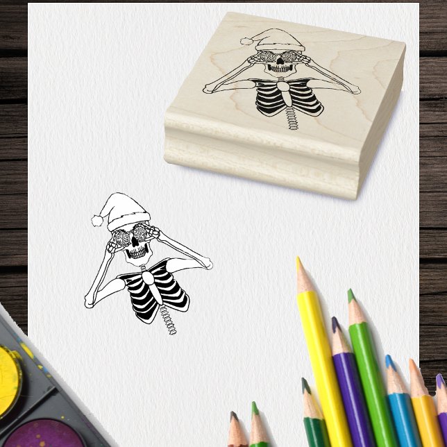 Funny Skeleton Drawing Holding ornaments Santa Hat Rubber Stamp (Fun Christmas skeleton Santa hat holding ornaments on craft stamp.)