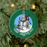 Funny Snowman Merry Christmas Add The Year Cartoon Ceramic Ornament<br><div class="desc">A funny skiing snowman ornament for your Christmas tree. Use "Personalise this template" to tweak the text or year and make a unique customised xmas gift. The tree decoration features a whimsical cartoon of an excited snowman with a carrot nose, dashing downhill through the snow on skis, in woolly winter...</div>