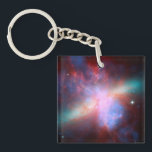 Galaxy M82 Key Ring<br><div class="desc">This image shows a stunning view of a Starburst galaxy produced by space telescopes. M82 is a galaxy about 12 million light years from Earth that is undergoing a burst of star formation. X-rays from Chandra (blue) show gas being blasted away from the galaxy's disc as a bounty of stars...</div>