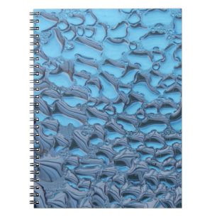 Gentle raindrops on blue glass notebook