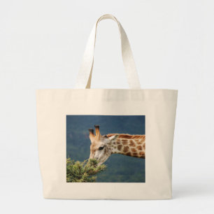 Giraffe eating some leaves large tote bag