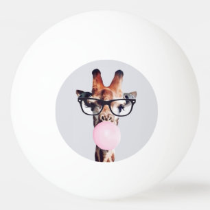 Giraffe wearing glasses blowing a pink bubble gum ping pong ball