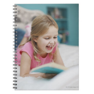 Girl laying in bed reading book