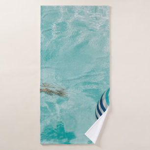Girl wearing swimsuit and swims in swimming pool bath towel