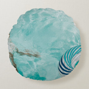 Girl wearing swimsuit and swims in swimming pool round cushion