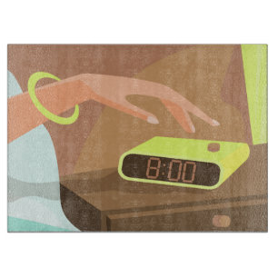 Girls hand pushing on alarm clock snooze button cutting board
