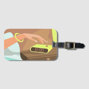 Girls hand pushing on alarm clock snooze button luggage tag