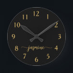 Girly Black Gold Minimalist Monogram Script Round Clock<br><div class="desc">Girly Simple Minimalist Black And Gold Monogram Name Script Custom Personalised Round Clock. These design featuring your first name in a pretty hand lettered style swash tail font signature typography on black and gold. These are easy to customise it. Great stylish feminine housewarming gift, also for birthday, mother’s day, wedding,...</div>