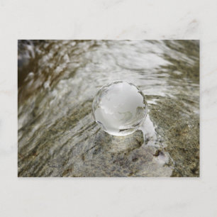 Glass globe on the water stream postcard