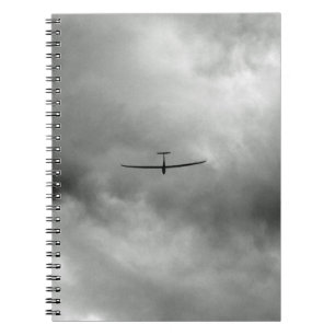 Glider flying in grey sky notebook
