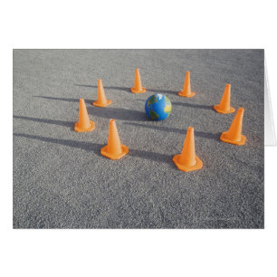 Globe on sand outdoors surrounded by traffic