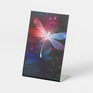 Glowing red dragonfly pedestal sign
