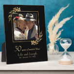 Gold Black 50th Wedding Anniversary Couple Photo Plaque<br><div class="desc">Here's a wonderful memorabilia gift for your family or friends celebrating their 50th wedding anniversary. This design features a photo of the happy couple framed by faux gold eucalyptus sprigs together with the words "50 years of wedded bliss!" followed by their first names and the date they were married. All...</div>