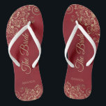 Gold Frills Crimson Red Elegant The Bride Wedding Thongs<br><div class="desc">Dance the night away with these beautiful wedding flip flops. Designed for the bride, they feature a simple yet elegant design with gold coloured script lettering on a crimson red background and fancy golden lace curls and swirls. Beautiful way to stay fancy and appropriate while giving your feet a break...</div>