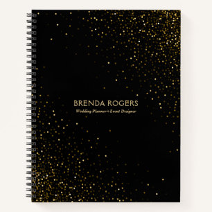 Gold glitter sparkles on black notebook