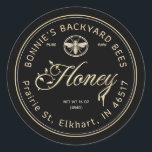 Gold Honey Script Floral Font Heraldic Bee Black Classic Round Sticker<br><div class="desc">Personalise with your apiary name and address and honey net weight. Vintage heraldic bee design. Gold text and illustration on a black background. Common honey net weight conversions: 8oz (227g),  12oz (340g),  16oz (454g),  32oz (907g),  5lb (2.27kg).</div>