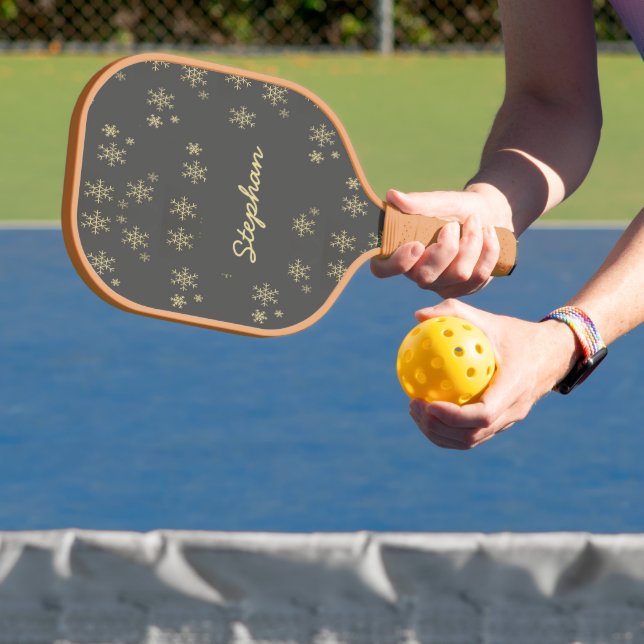 Gold snowflakes on grey pickleball paddle (Insitu)
