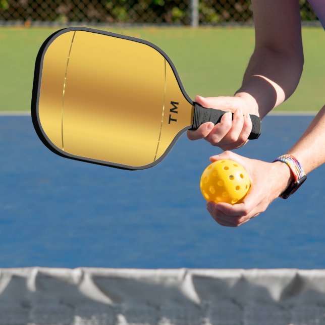 Gold tones background, shiny gold stripe pickleball paddle (Insitu)
