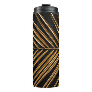 Golden painted date palm leaf closeup on abstract thermal tumbler