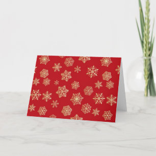 Golden snowflakes against deep red holiday card