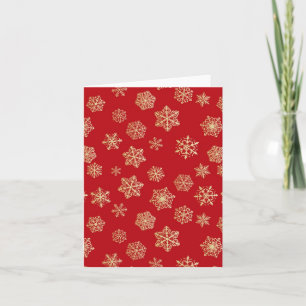 Golden snowflakes against deep red holiday card