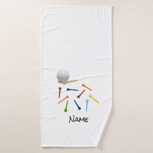 Golf ball and colourful tees on white bath towel