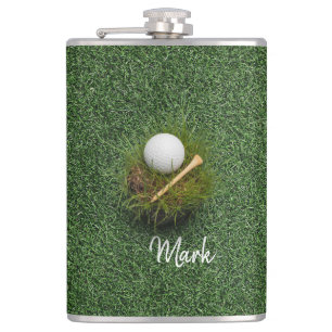 Golf ball on green grass hip flask