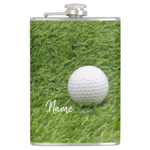 Golf ball on green grass hip flask