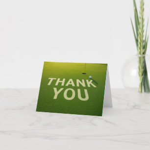 Golf  ball with word thank you on putting green card