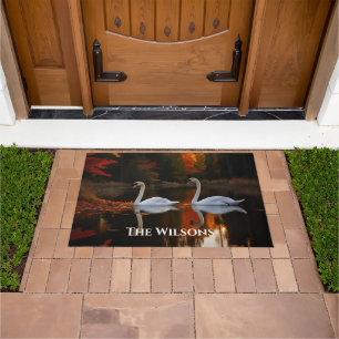 Graceful White Swans Gliding Across Autumn Pond Doormat