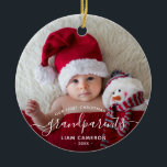 Grandparents First Christmas Photo White Script Ceramic Ornament<br><div class="desc">Help them celebrate their first grandchild with this beautiful modern keepsake ornament. The white text reads "Our first Christmas as grandparents, " with the word "grandparents" in elegant handwriting script with flourishes before and after. Easily replace the sample image with your favourite photo of the new baby, and add his...</div>