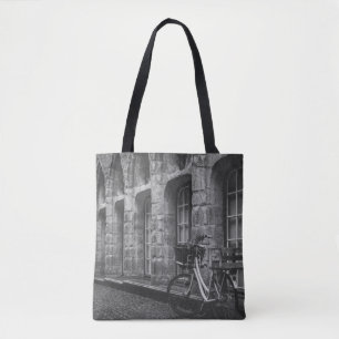 GRAYSCALE PHOTO OF BIKE PARKED BESIDE BUILDING TOTE BAG