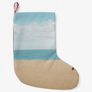 Green artificial palm tree on seashore small christmas stocking