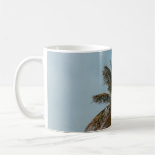 Green coconut tree under blue sky coffee mug